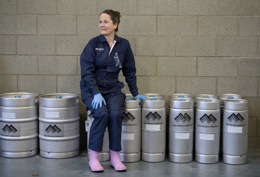 Teri sits on a row of GWM branded kegs in the MIC